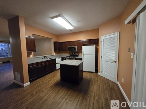 A kitchen with brown cabinets and a white fridge.