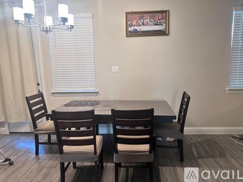 A dining room with a table and chairs.