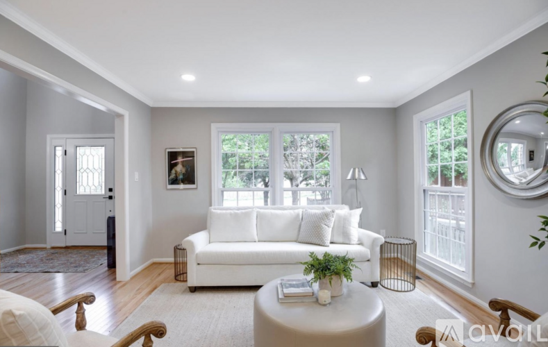 A living room with a white couch and a round table.
