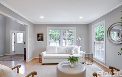A living room with a white couch and a round table.