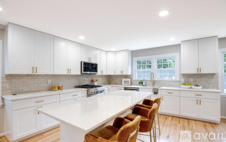 A modern kitchen with white cabinets and a central island.