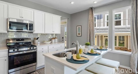 A kitchen with white cabinets and a stainless steel oven.