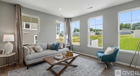 A living room with a grey couch, a coffee table, and a blue armchair.