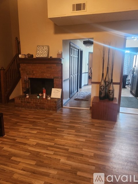 A living room with a fireplace and a painting of two people.