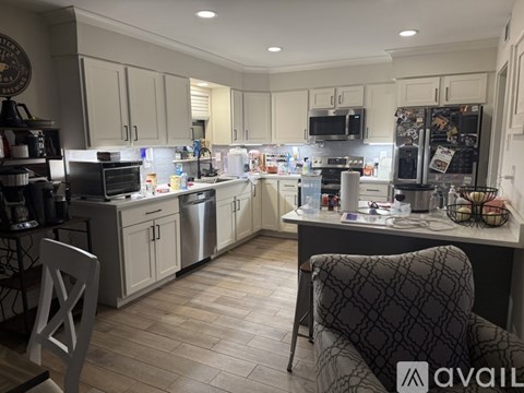 A kitchen with a black fridge and a black chair.