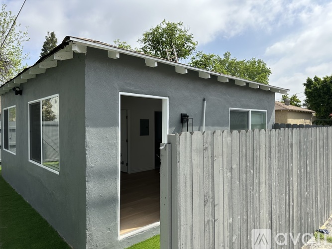 A grey house with a white door and windows.