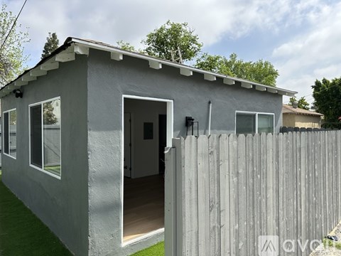 A grey house with a white door and windows.