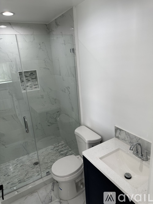 A white toilet sits next to a sink in a bathroom.