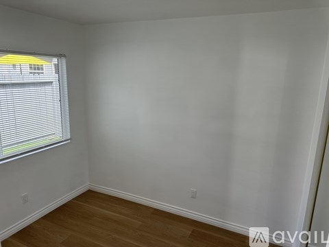 A room with a window and wooden flooring.