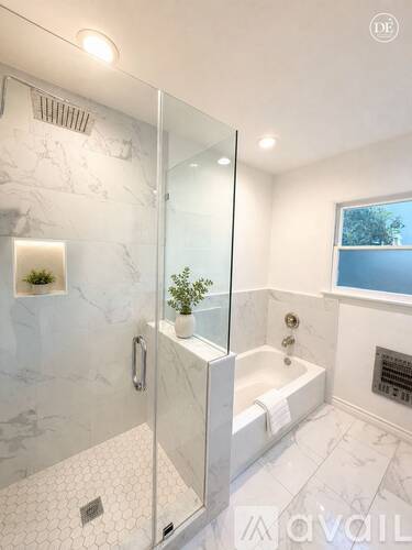 A bathroom with a walk-in shower and a window.