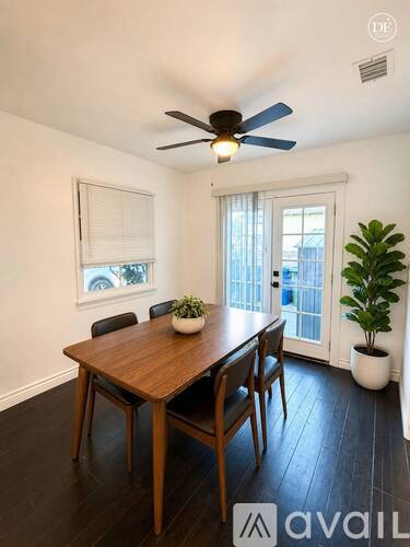 A dining room with a wooden table and chairs.