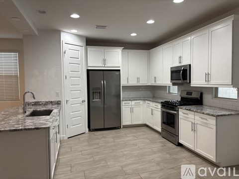 A kitchen with white cabinets and a granite countertop.