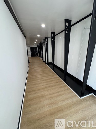 A long hallway with black metal railings and wooden floors.