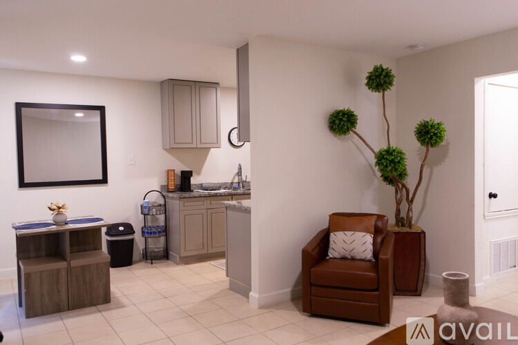 A living room with a brown leather chair and a brown plant.