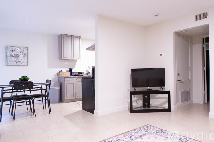 A living room with a black television set on a stand.