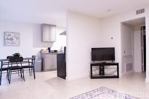 A living room with a black television set on a stand.