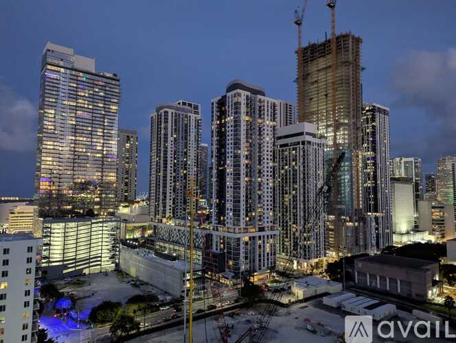 A cityscape at dusk with a building under construction prominently in the foreground.