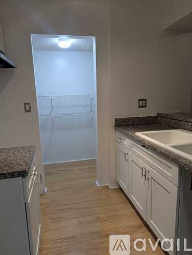 A kitchen with white cabinets and a granite countertop.