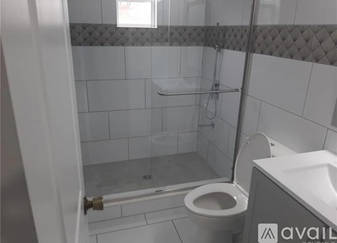A bathroom with a toilet, sink, and shower.