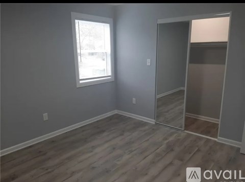 A room with a window and wooden flooring.