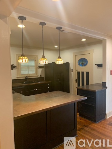 A kitchen with a black counter top and cabinets.