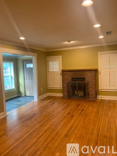 A room with a fireplace and wood flooring.