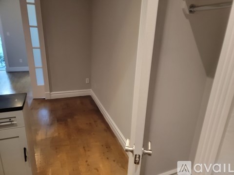 A kitchen with a wooden floor and white walls.