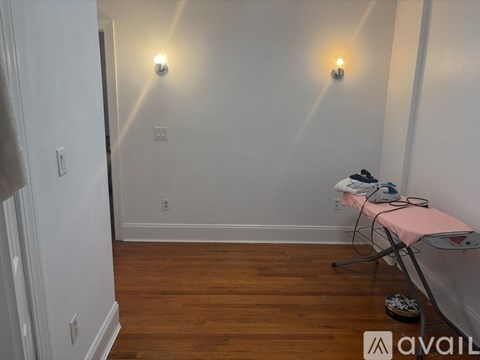 A room with a wooden floor and two lights on the wall.