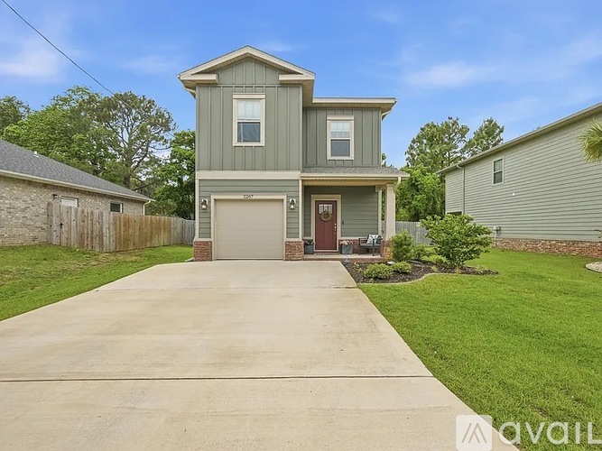 A house with a grey facade and a brown door is for sale.