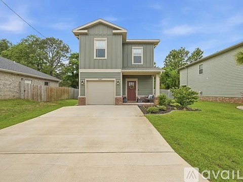 A house with a grey facade and a brown door is for sale.