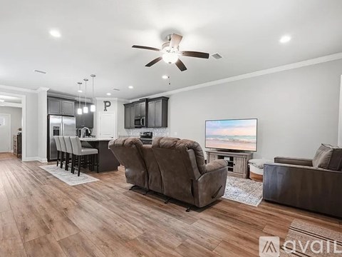 A living room with a brown couch and a television.