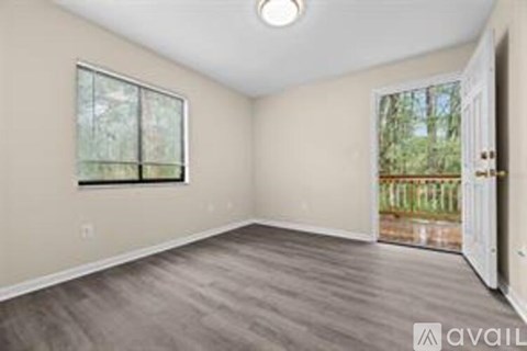 A room with a window and a door leading to a backyard.