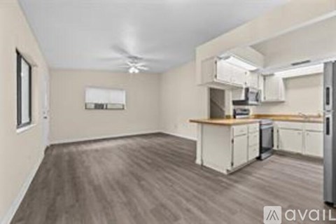 A kitchen with white cabinets and a refrigerator.
