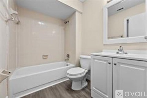 A white bathroom with a tub, toilet and sink.