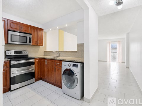 A kitchen with a washing machine in the middle of the counter.