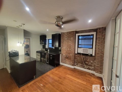 A room with a brick wall and wooden floors.