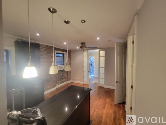 A kitchen with a black countertop and pendant lights.