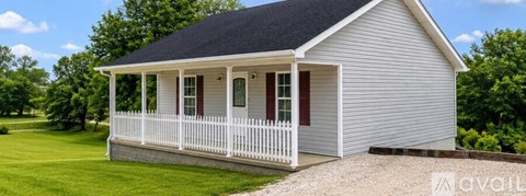 A small house with a porch and a gabled roof.