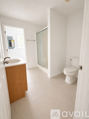 A bathroom with a toilet, sink, and shower.