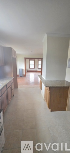 A kitchen with wooden cabinets and a tiled floor.
