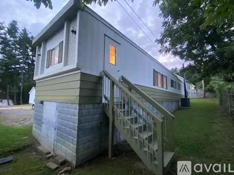 A house with a grey exterior and a staircase leading to the front door.