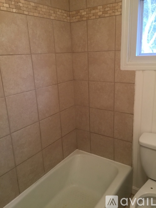 A bathroom with a tub and toilet.