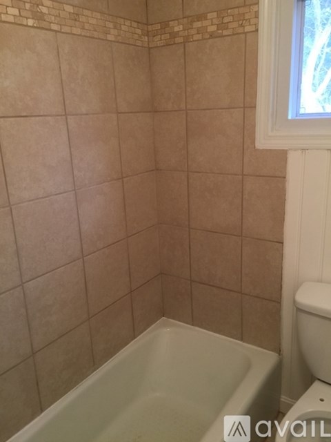 A bathroom with a tub and toilet.