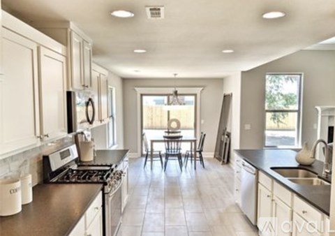 A kitchen with white cabinets and a black stove top oven.