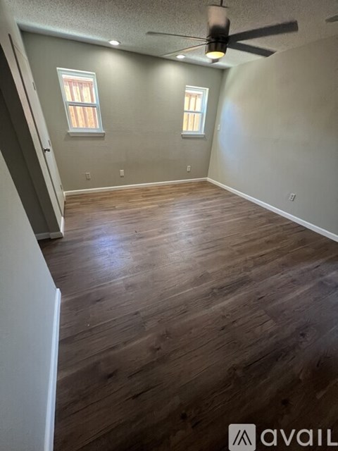 A room with wooden flooring and a ceiling fan.