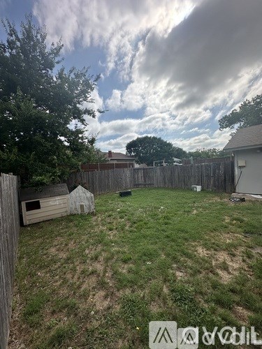 A backyard with a wooden fence and a small shed.