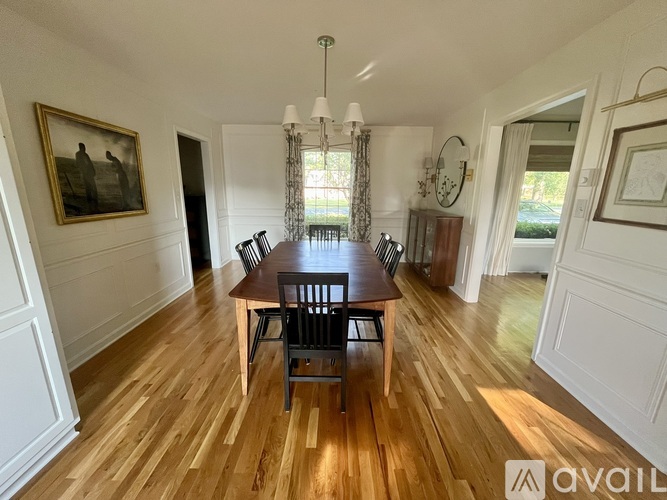 A dining room with a wooden table and chairs.
