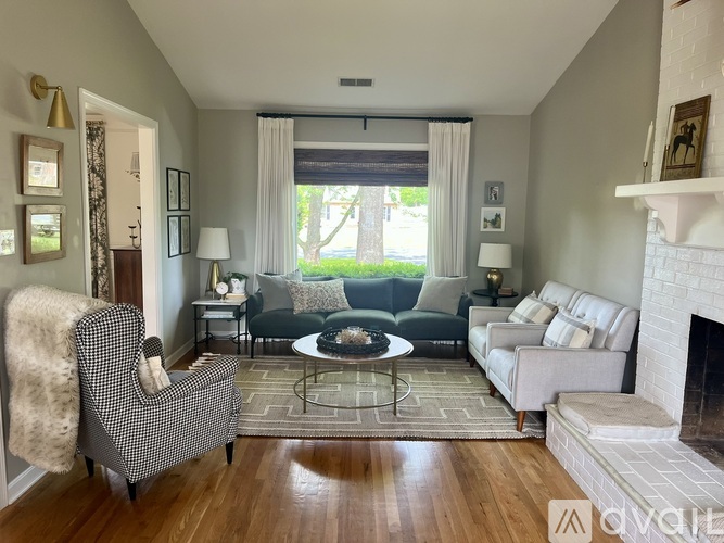A living room with a fireplace and a grey sofa.