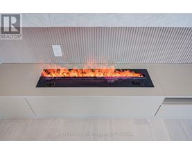 A modern fireplace with flames in a living room.