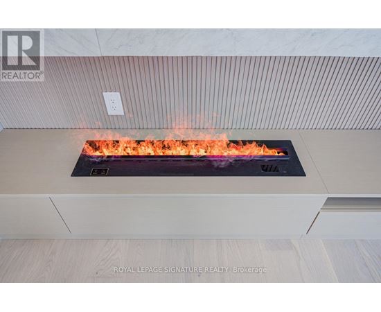 A modern fireplace with flames in a living room.